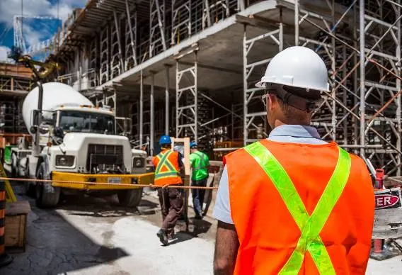 A construction site with construction workers and scaffolding around the building